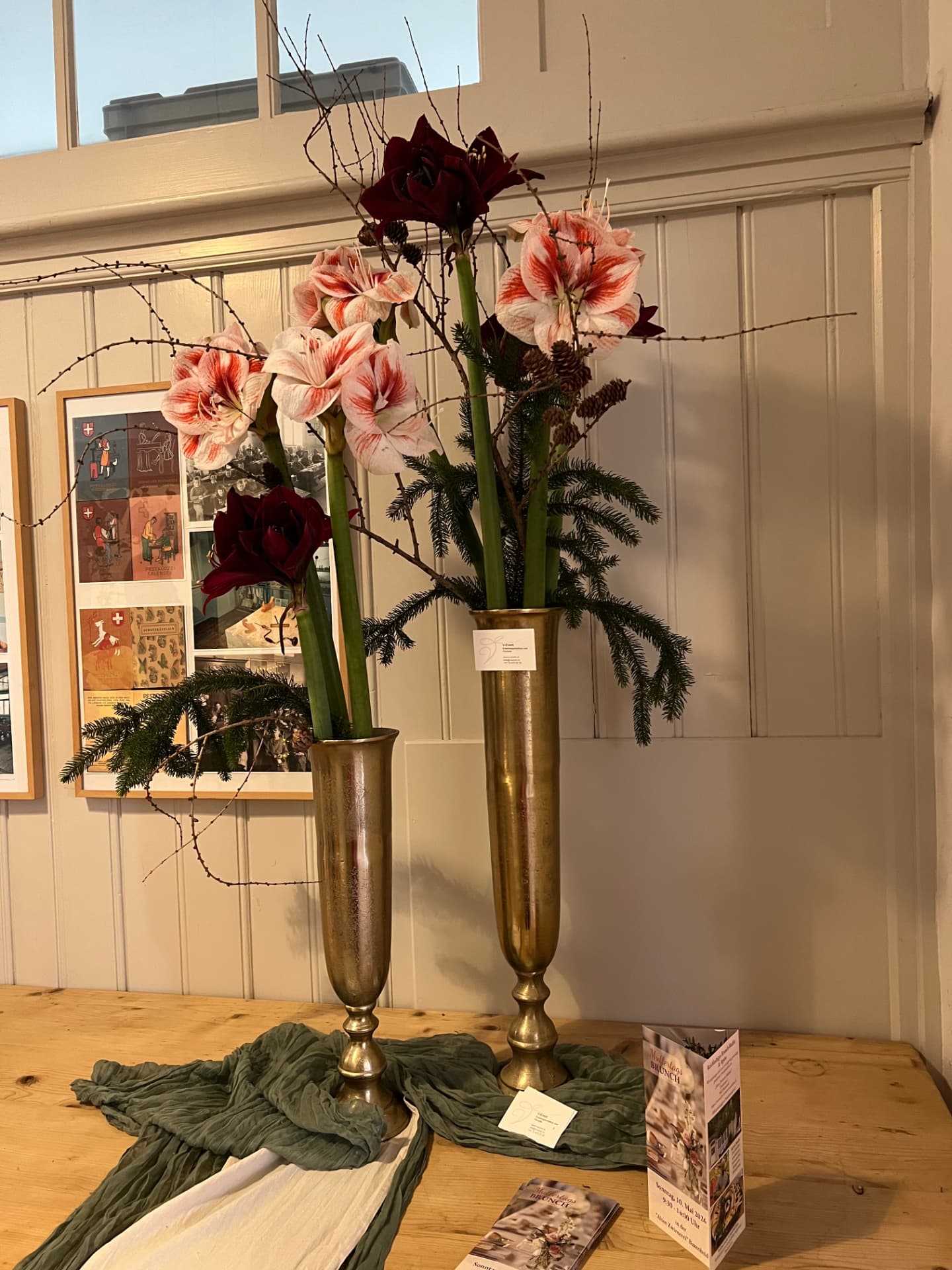 Blumenarrangement mit Amaryllis in goldenen Vasen